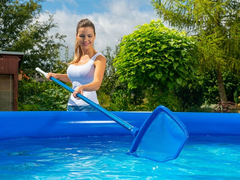 Woman cleaning an above-ground pool with a skimmer net.