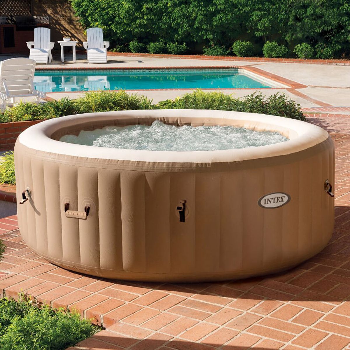 Inflatable hot tub on a patio with a pool in the background