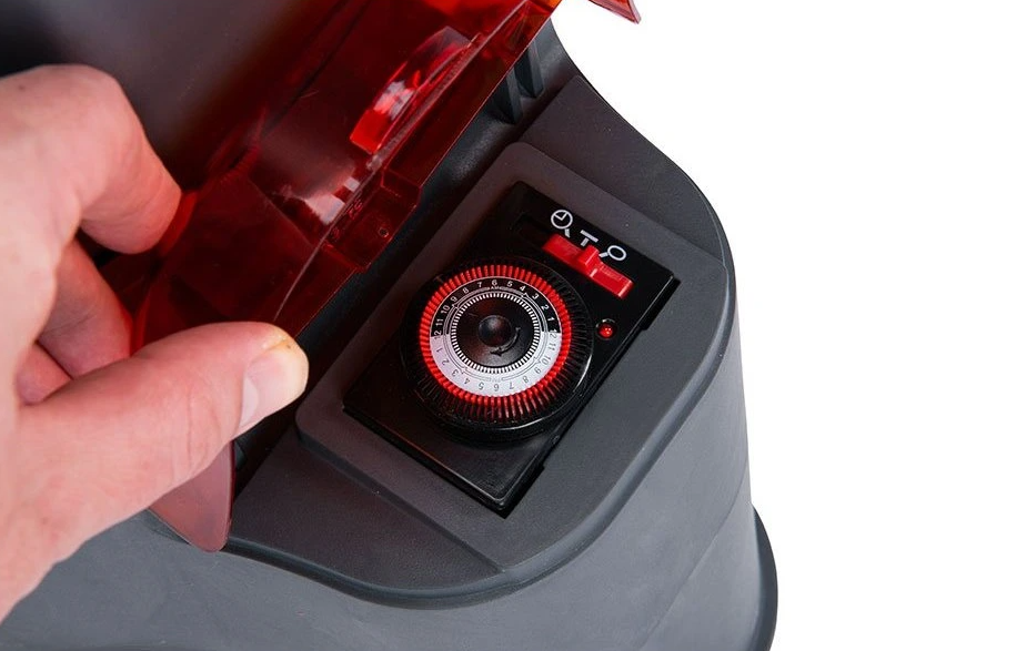 Hand using a red and black pool pump with a run timer.