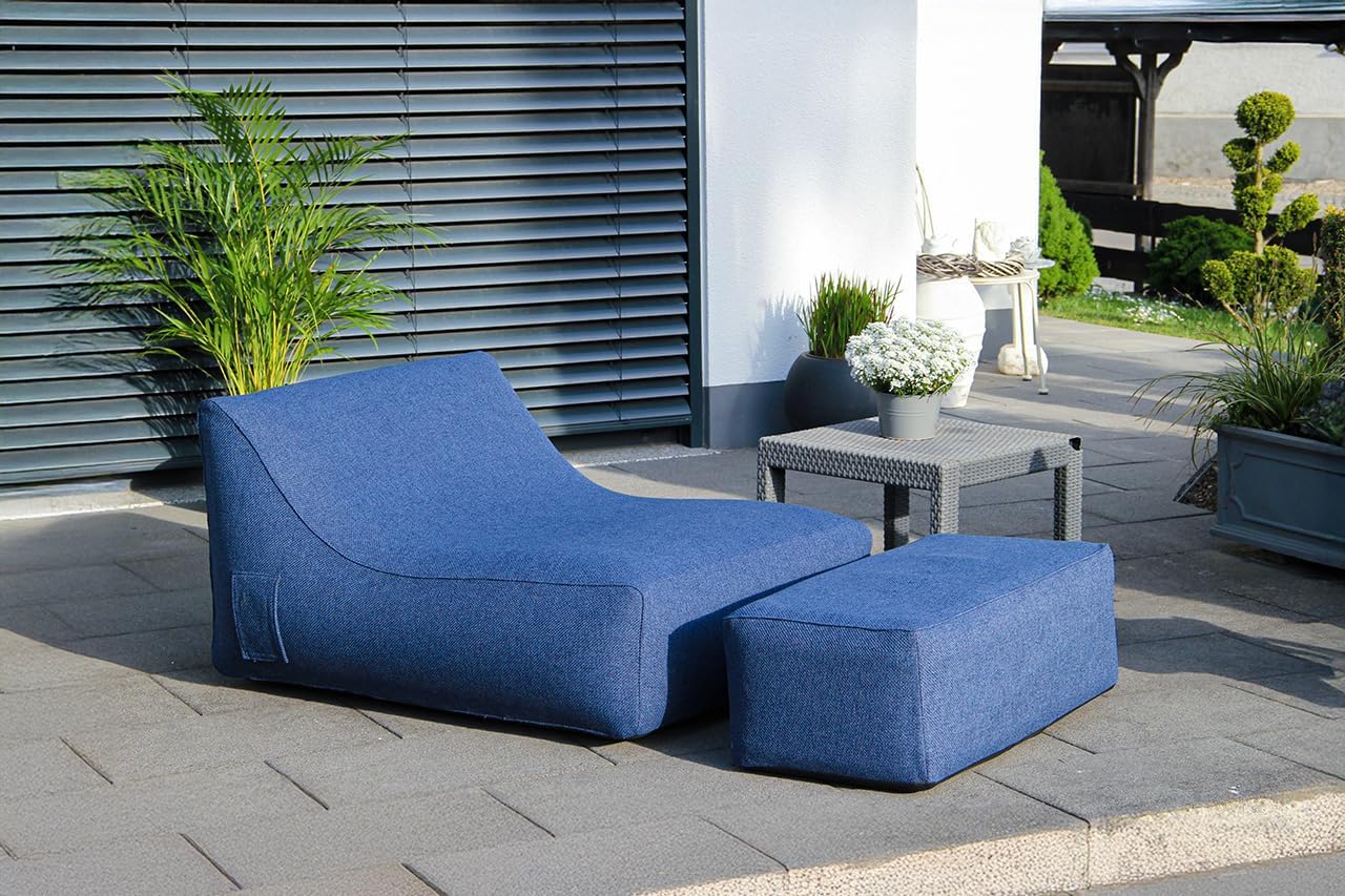 Blue outdoor lounge chair and ottoman on a patio with plants and a building in the background