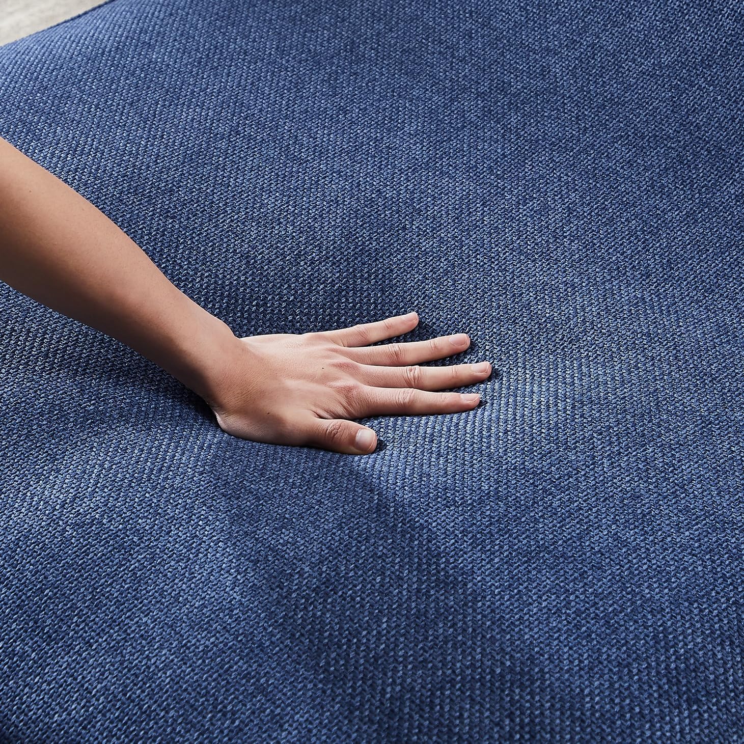 Hand touching a textured blue cover