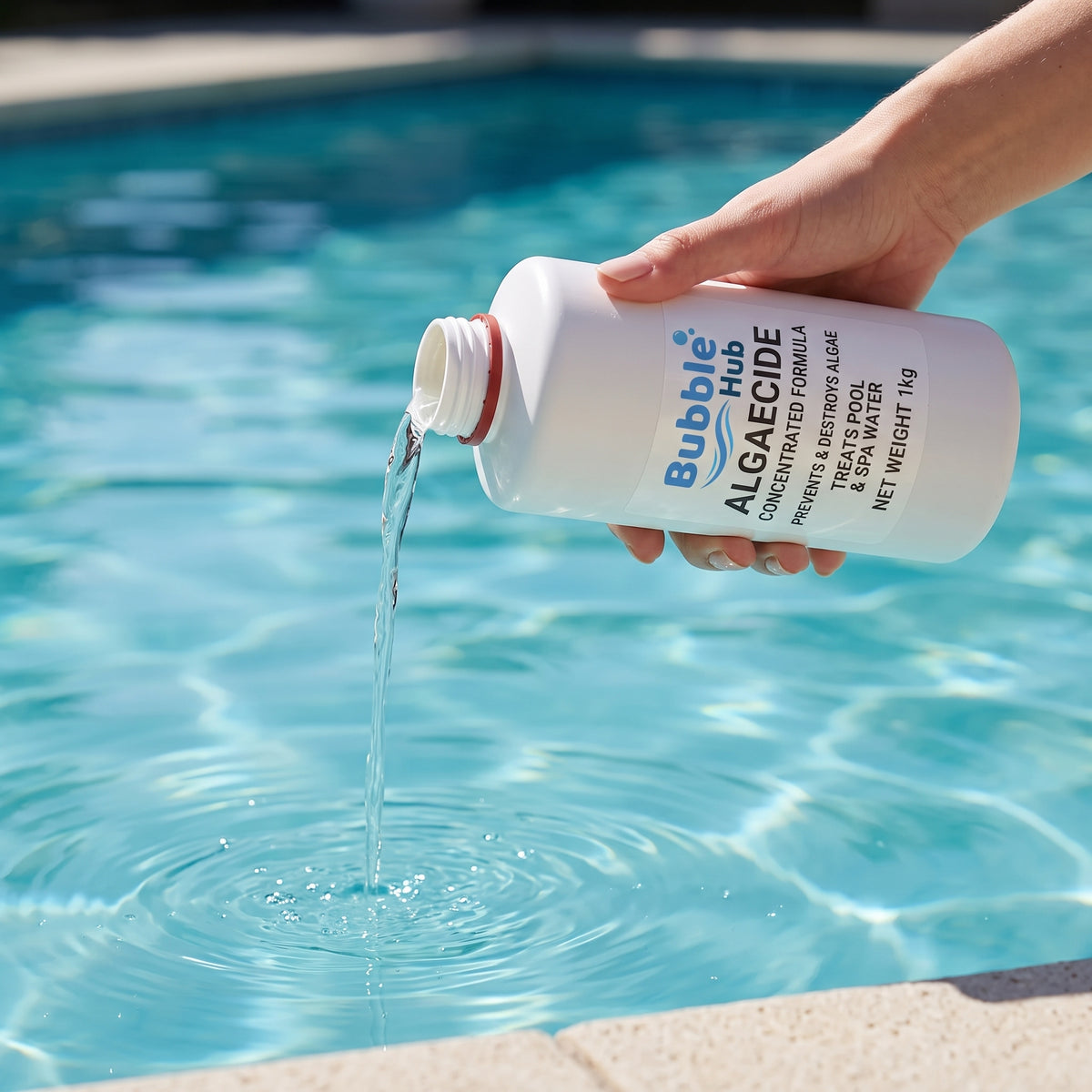 A hand pouring liquid from a white Bubble Hub Algaecide bottle into a swimming pool, creating ripples on the blue water.
