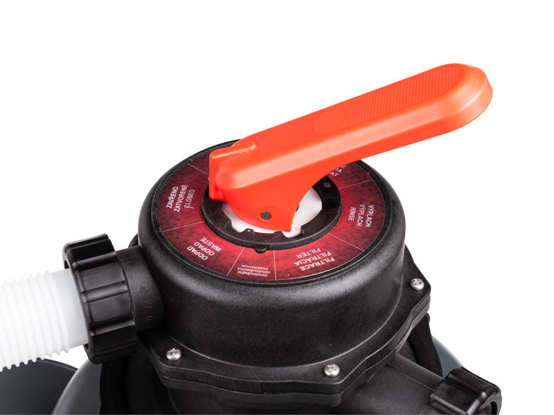 Close-up of a black pool sand filter valve with a bright orange handle and a red dial showing filter settings, with a white hose connected on the left.